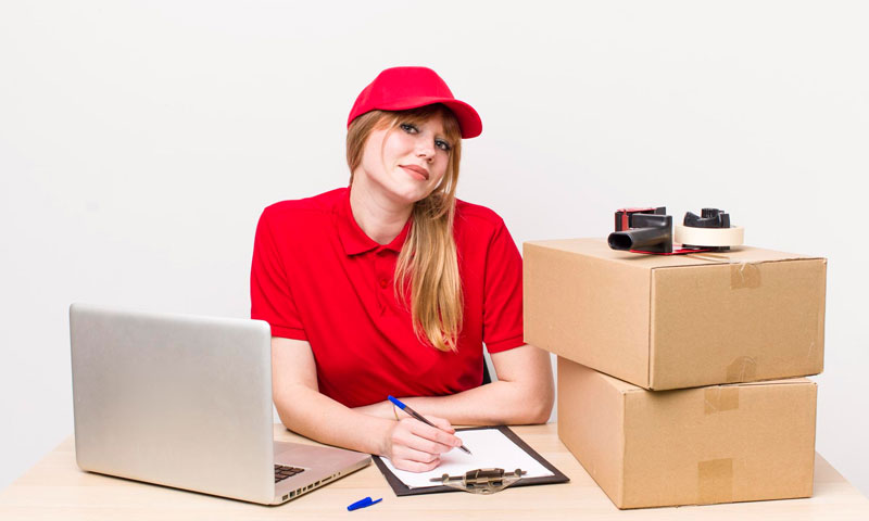 Mujer con computador portatil y cajas en escritorio gestionando importaciones express de China, Estados Unidos, España y demás países: Directo a tu puerta o taller